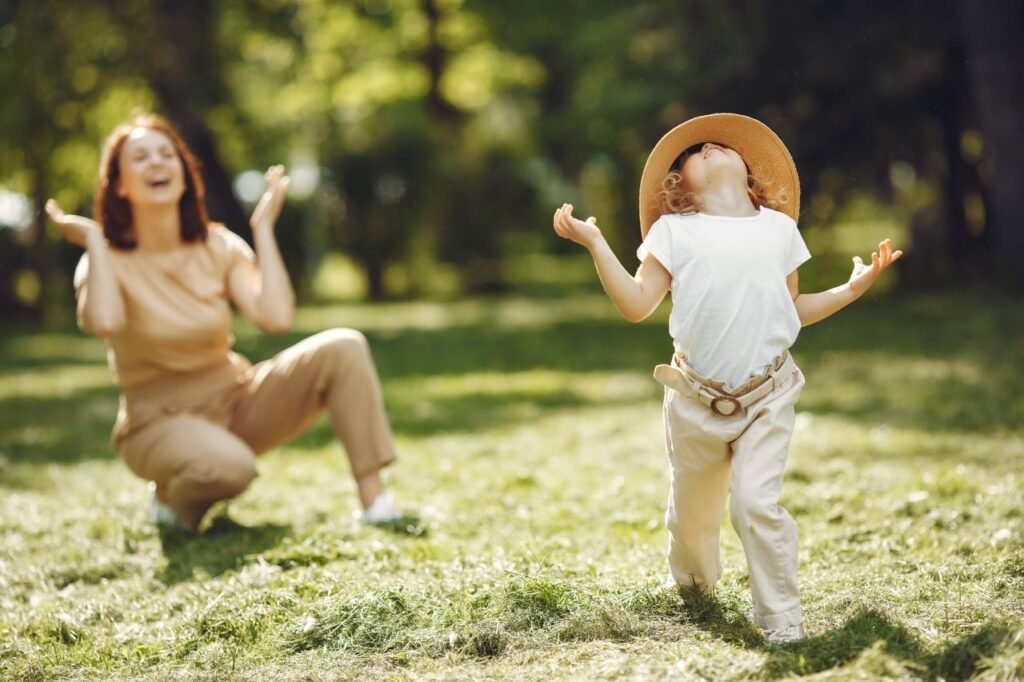 A mother and child joyfully playing together in a sunny park, embracing nature and happiness.