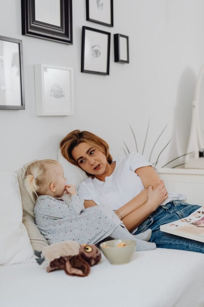 A mother and her child enjoying a bonding moment on a cozy bed at home.